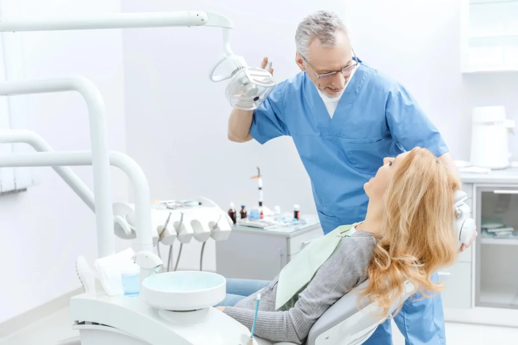 Dentist in Farmington Hills, MI consulting patient at a dental office.