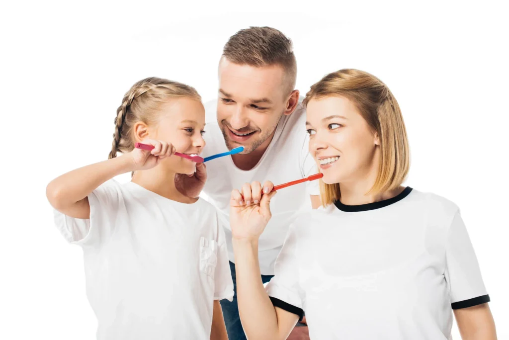Family brushing teeth together after an appointment at a family dentistry in Farmington Hills, MI.