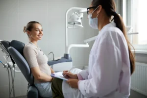 Female patient smiling at dentist in 48334, during visit.